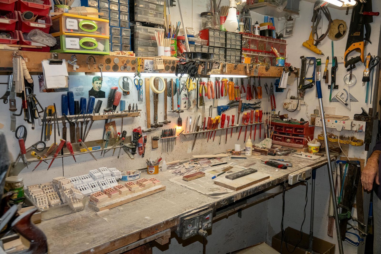 Workshop interior with tools neatly organized on walls and workbench.