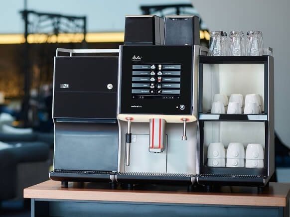 A coffee machine is sitting on top of a wooden table.