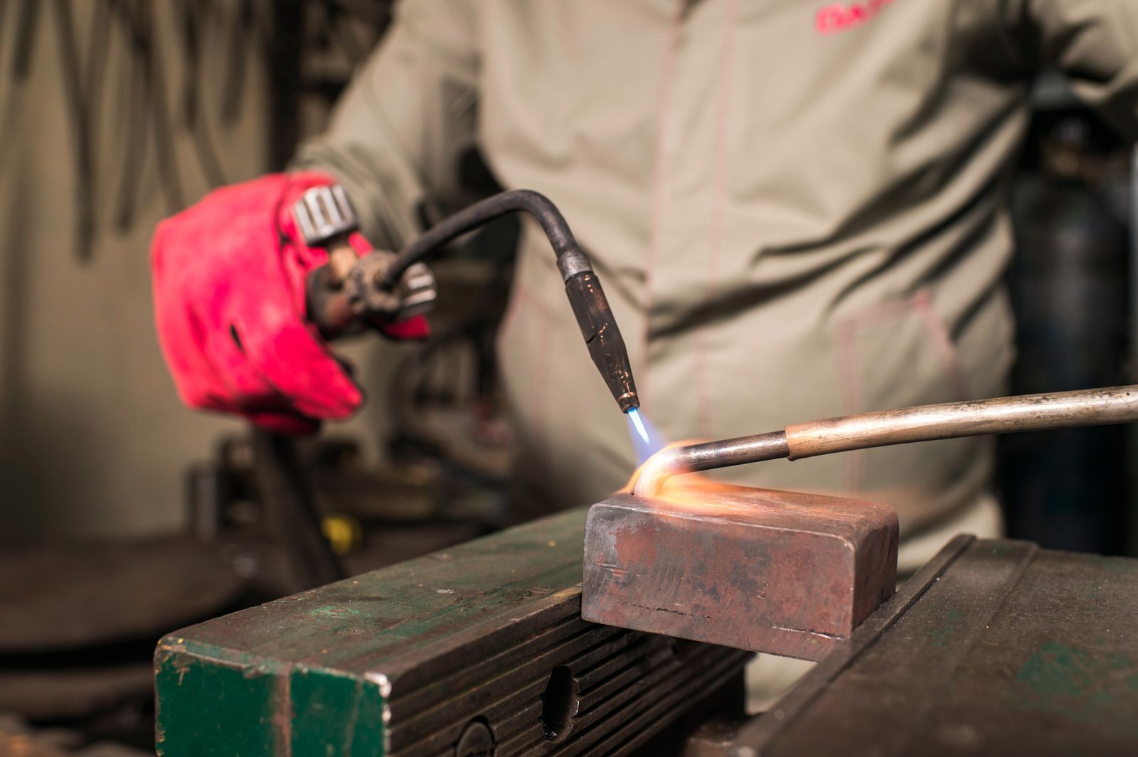 A man is cutting a piece of metal with a torch.