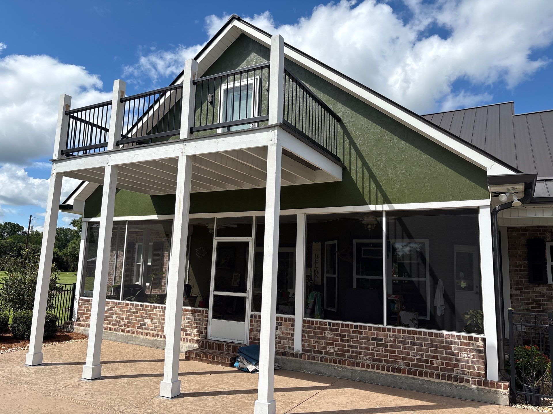 A house with a screened in porch and a balcony