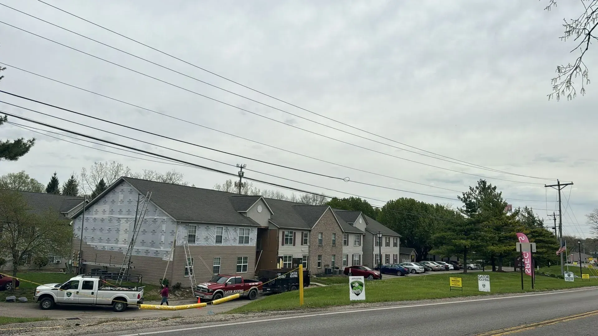 A white truck is parked in front of a building under construction.