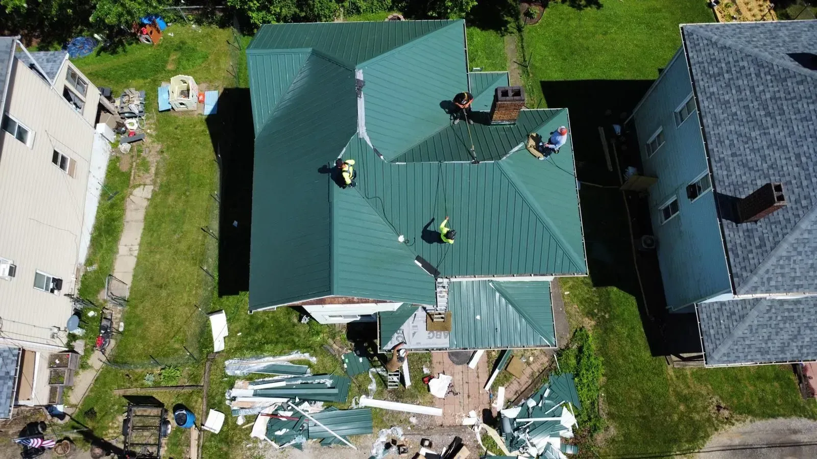 An aerial view of a house with a green roof being installed.
