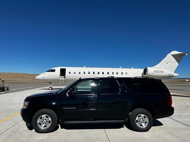 A white bus is parked on the side of a snowy road.