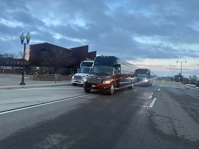 A row of buses are driving down a city street.