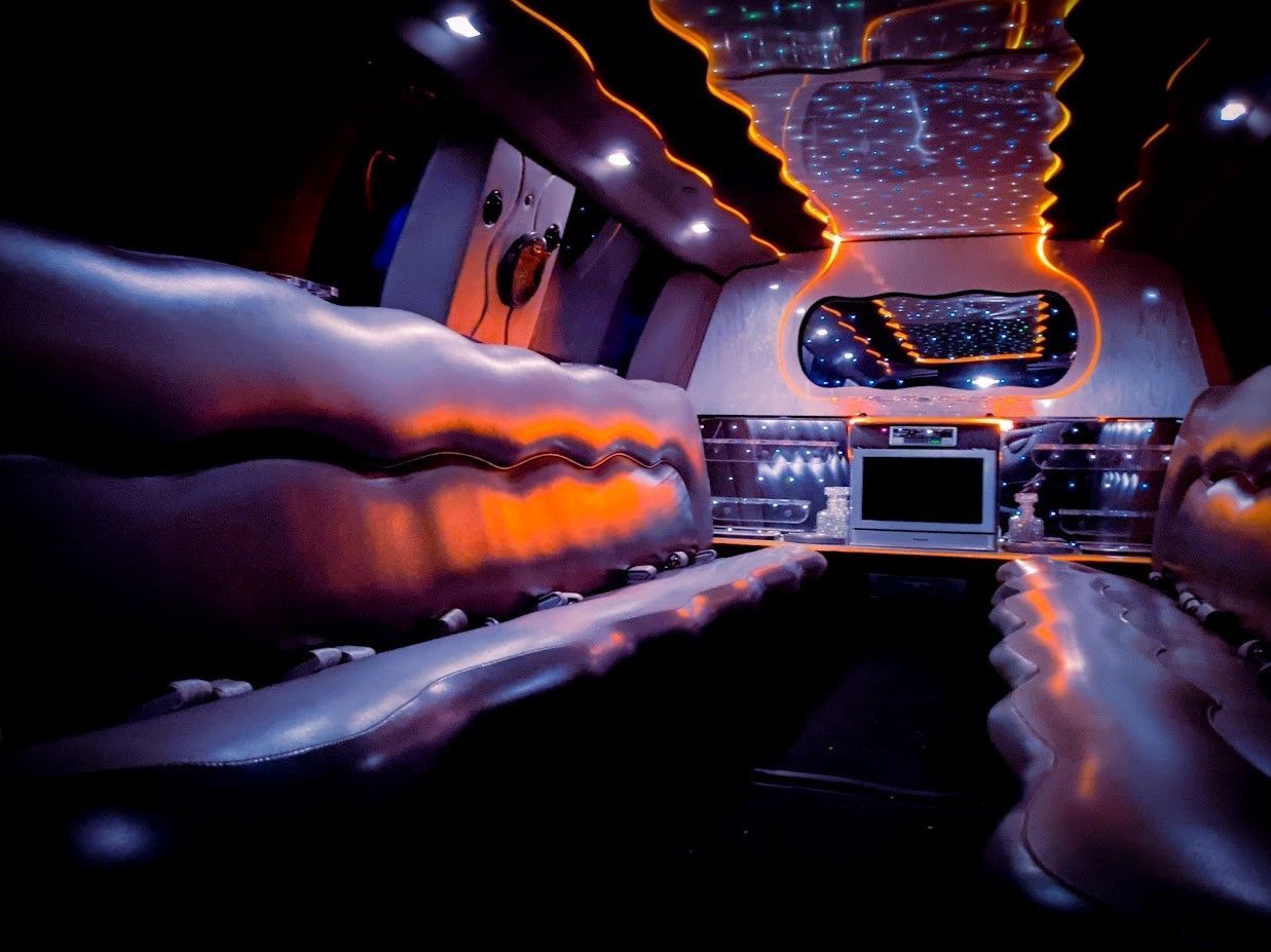 The inside of a limousine with a green light on the ceiling.