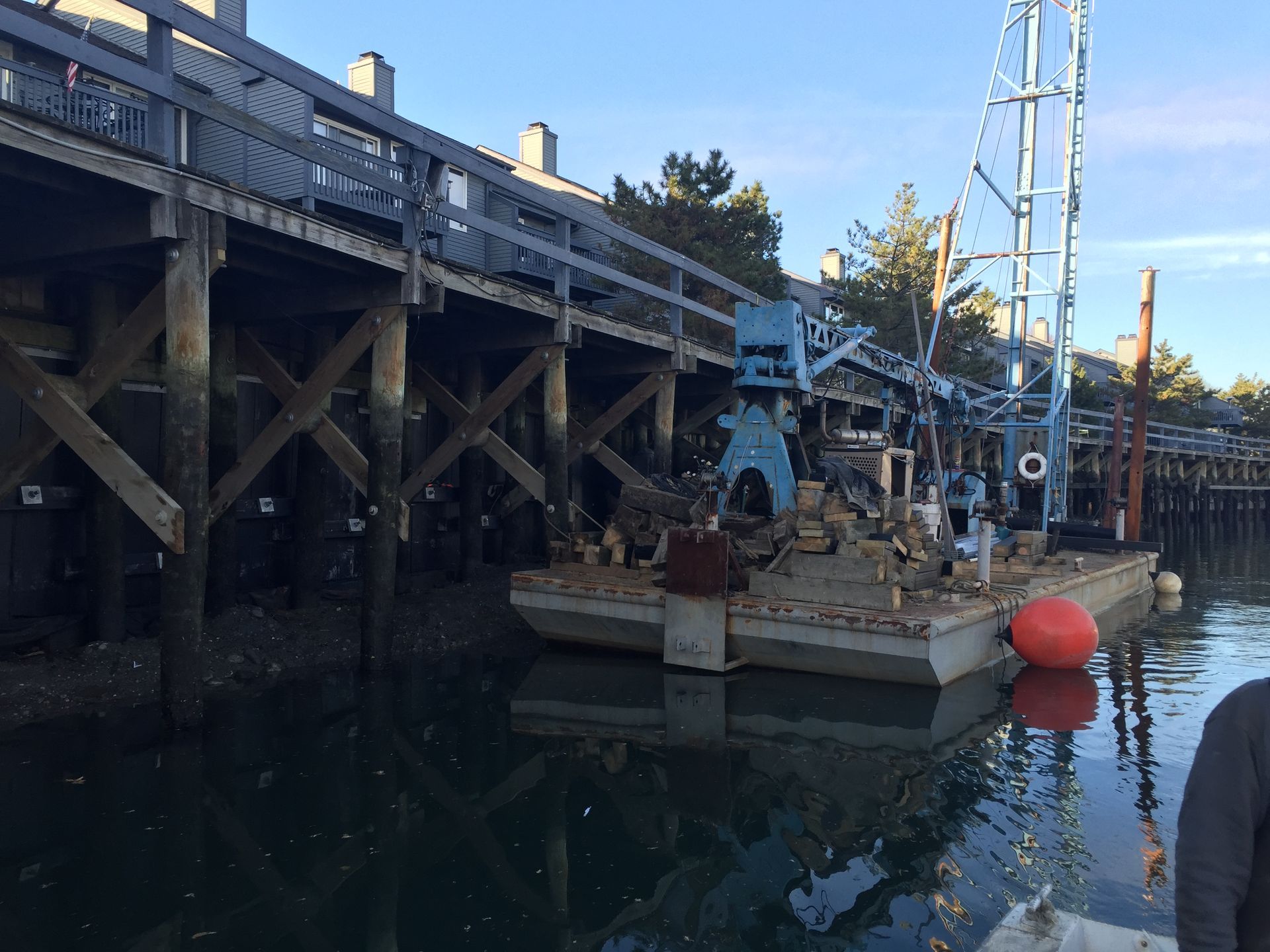 A boat is docked under a bridge in the water.
