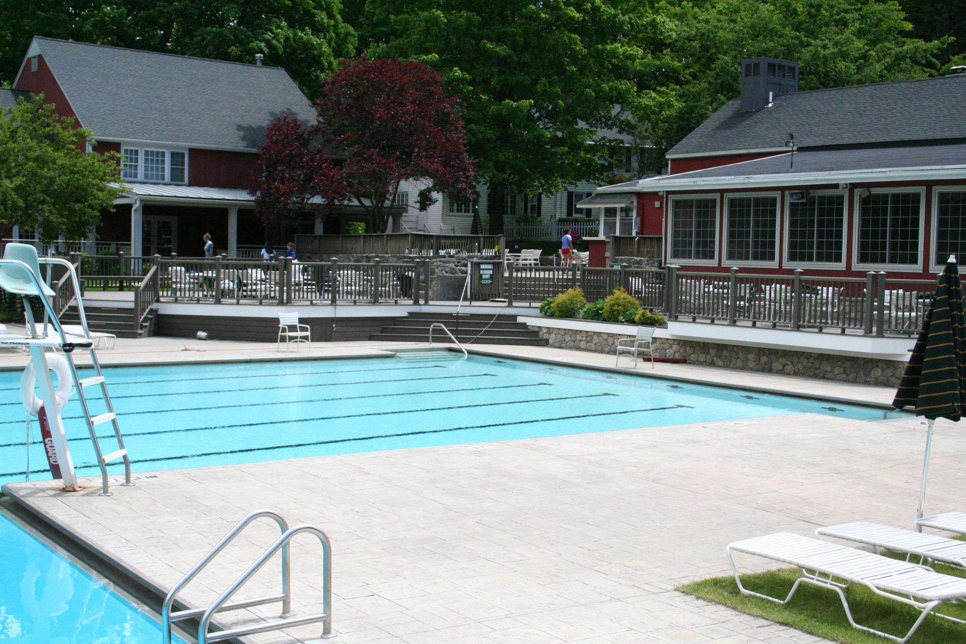 A large swimming pool is surrounded by chairs and umbrellas