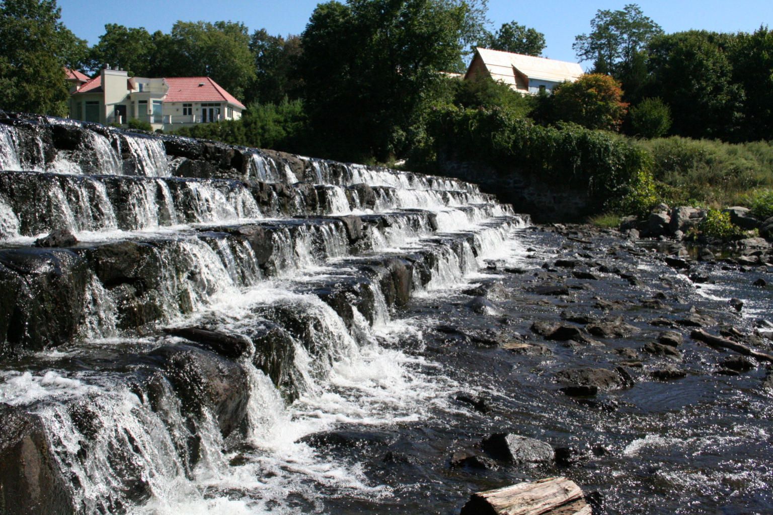 A waterfall with a house in the background