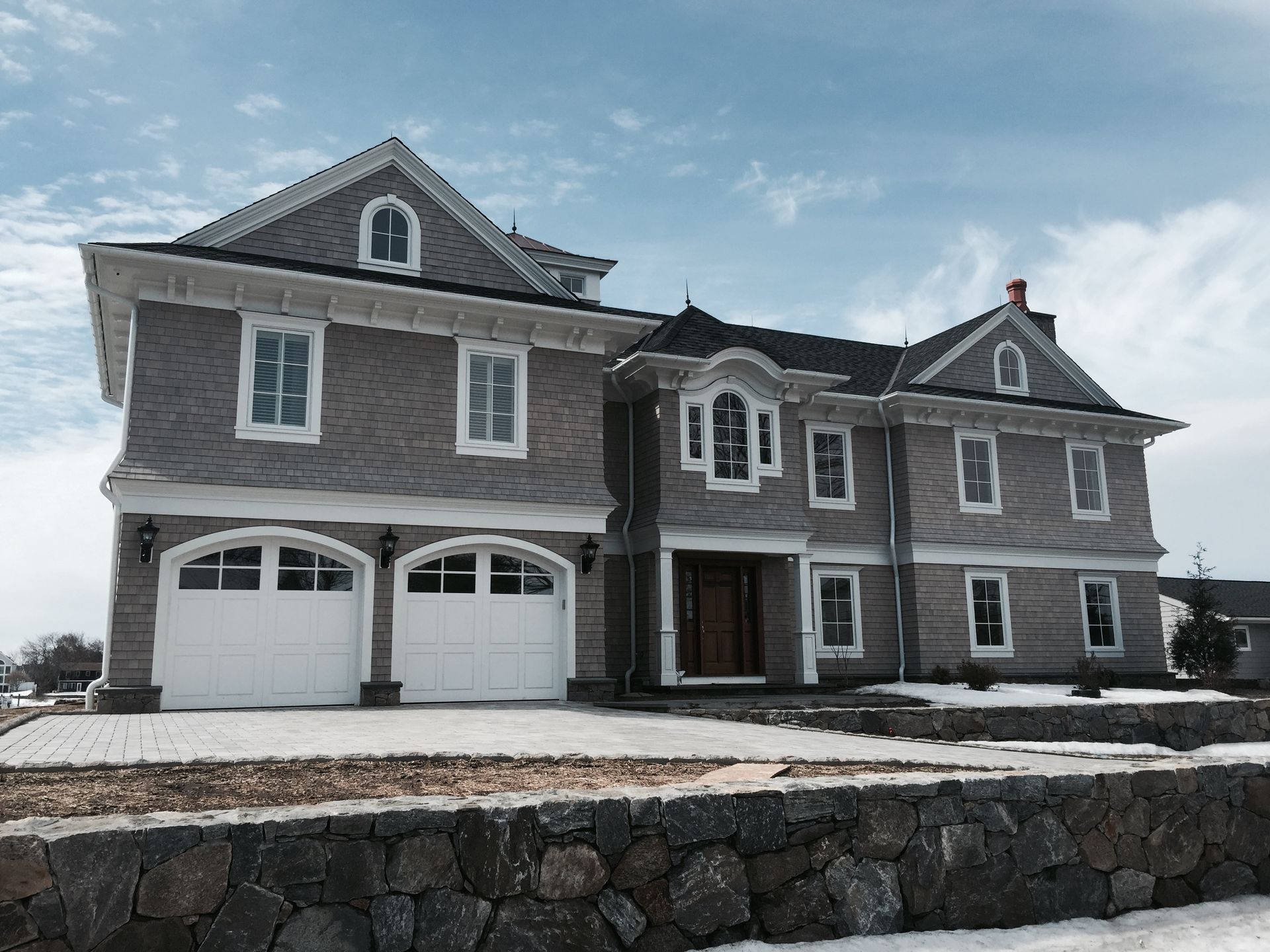 A large house with a stone wall in front of it