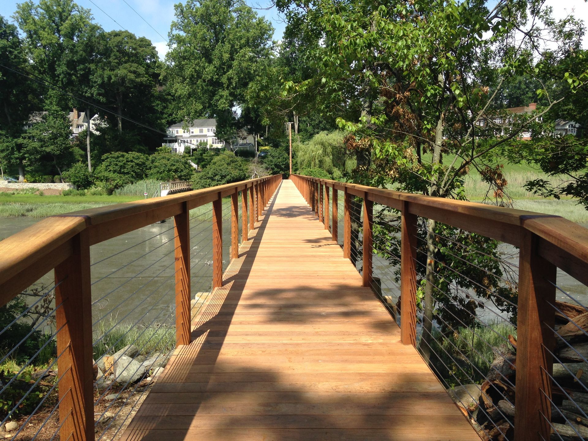 A wooden bridge over a body of water surrounded by trees