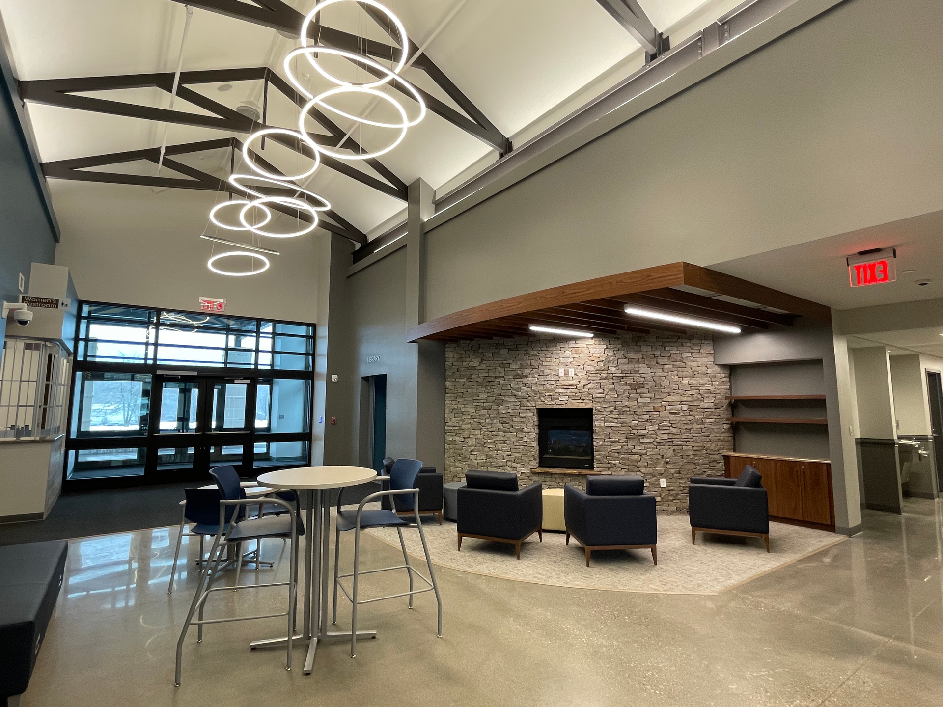 A living room with a fireplace and tables and chairs