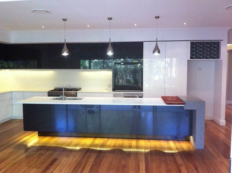 A Kitchen with Black Cabinets and White Counter Tops — Burns Custom Kitchens in Newcastle, NSW