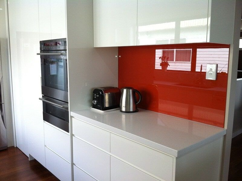 A Kitchen with White Cabinets and A Red Backsplash — Burns Custom Kitchens in Newcastle, NSW