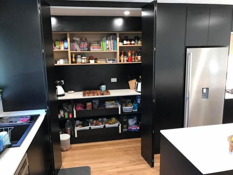 A Kitchen with Black Cabinets and A Stainless Steel Refrigerator — Burns Custom Kitchens in Newcastle, NSW
