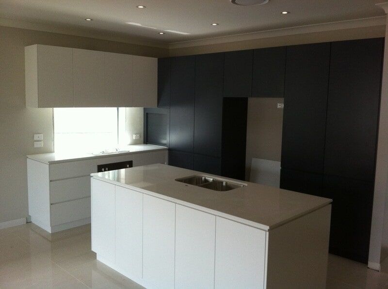 A Kitchen with White Cabinets and A Large Island — Burns Custom Kitchens in Newcastle, NSW
