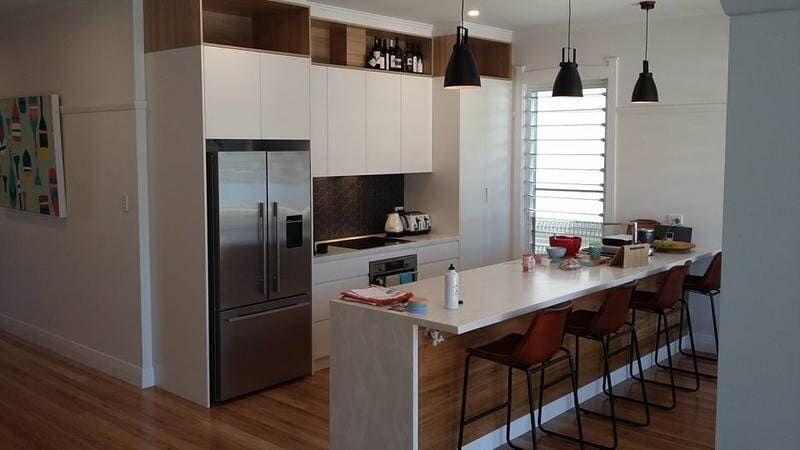 A Kitchen with White Cabinets, Stainless Steel Appliances, a Refrigerator and A Long Island — Burns Custom Kitchens in Newcastle, NSW
