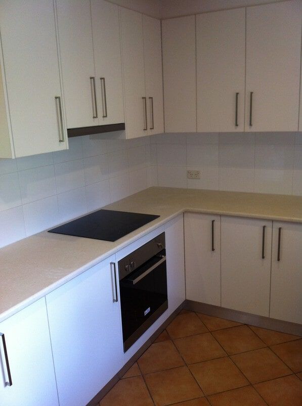 A Kitchen with White Cabinets and A Black Stove Top Oven — Burns Custom Kitchens in Newcastle, NSW