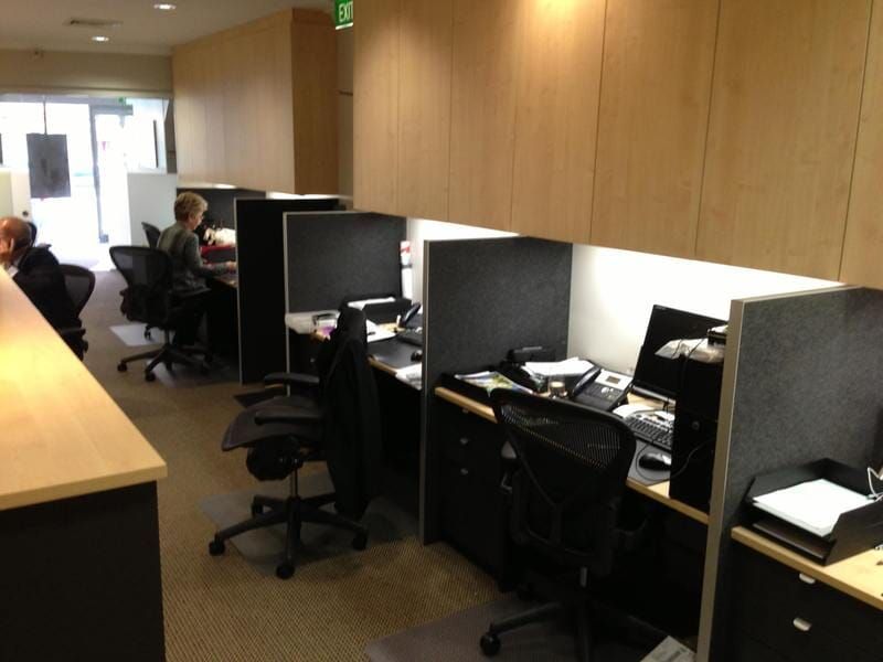 An Office with Cubicles and A Green Exit Sign — Burns Custom Kitchens in Newcastle, NSW