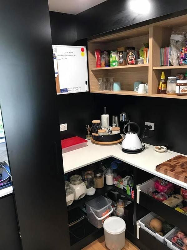 A Kitchen with A Lot of Shelves and Drawers and A White Board on The Wall — Burns Custom Kitchens in Newcastle, NSW