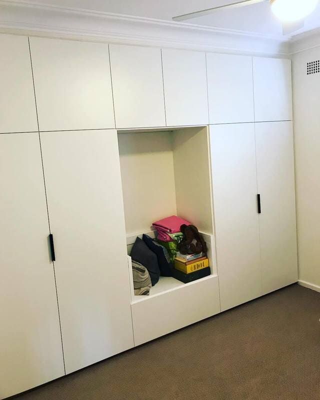 A Room with A Lot of White Cabinets and A Bench with Stuffed Animals in It — Burns Custom Kitchens in Newcastle, NSW