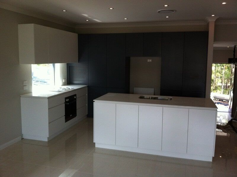 A Kitchen with White Cabinets and A Large Island — Burns Custom Kitchens in Newcastle, NSW