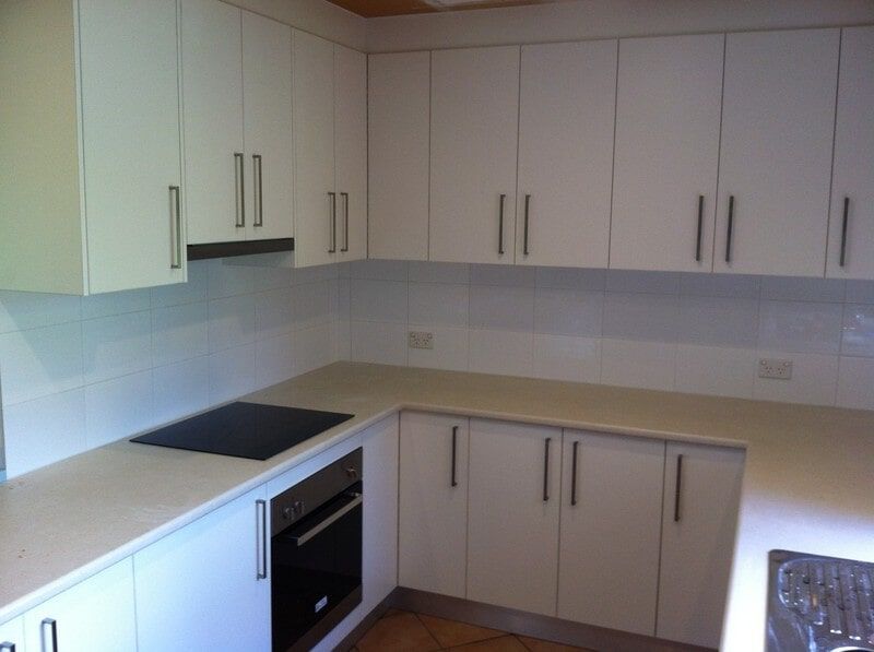 A Kitchen with White Cabinets and A Black Stove Top Oven — Burns Custom Kitchens in Newcastle, NSW