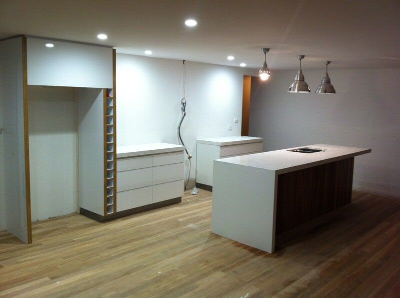 A Kitchen with A Large Island and White Cabinets — Burns Custom Kitchens in Newcastle, NSW