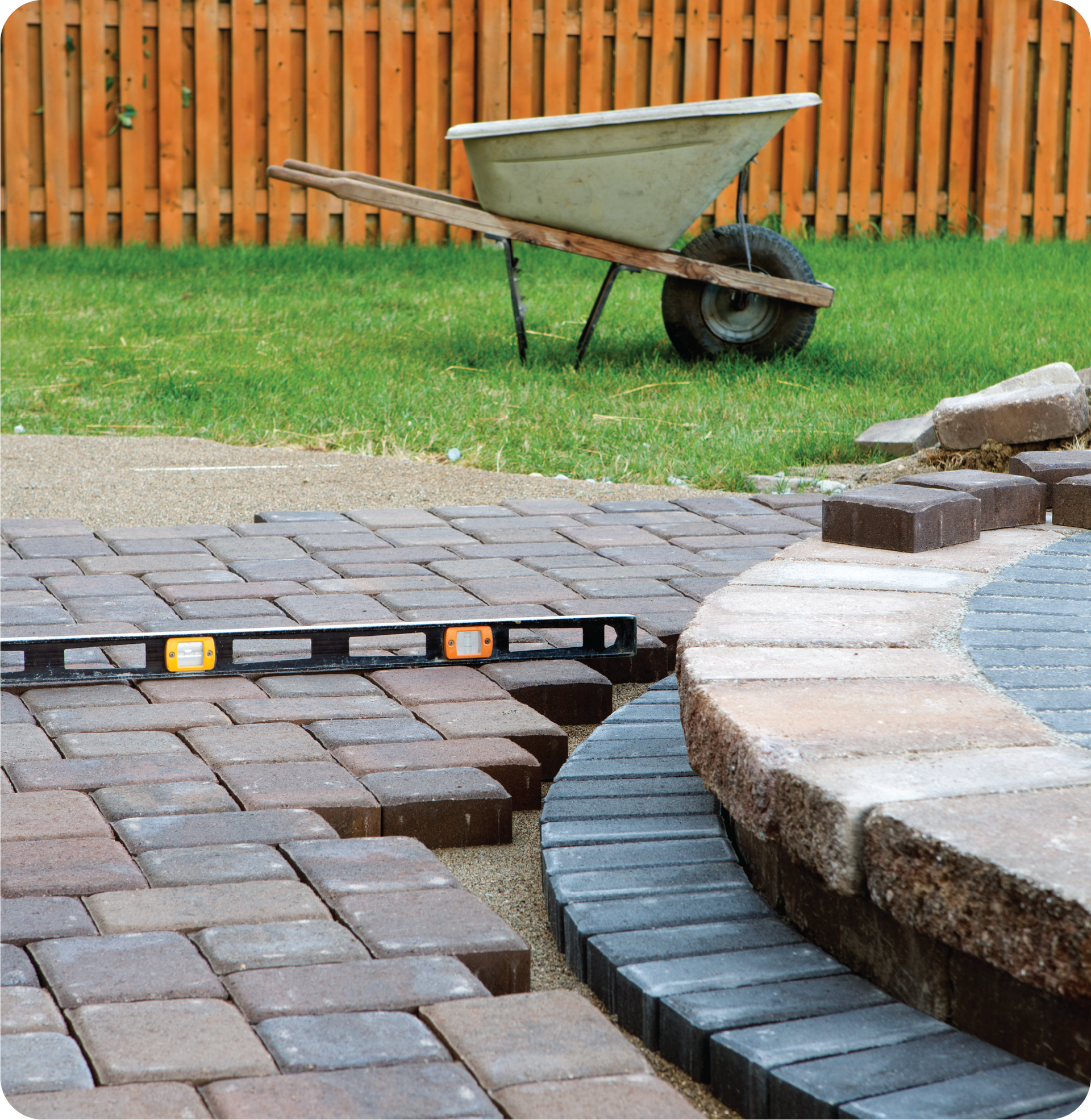 A wheelbarrow is sitting in the grass next to a level