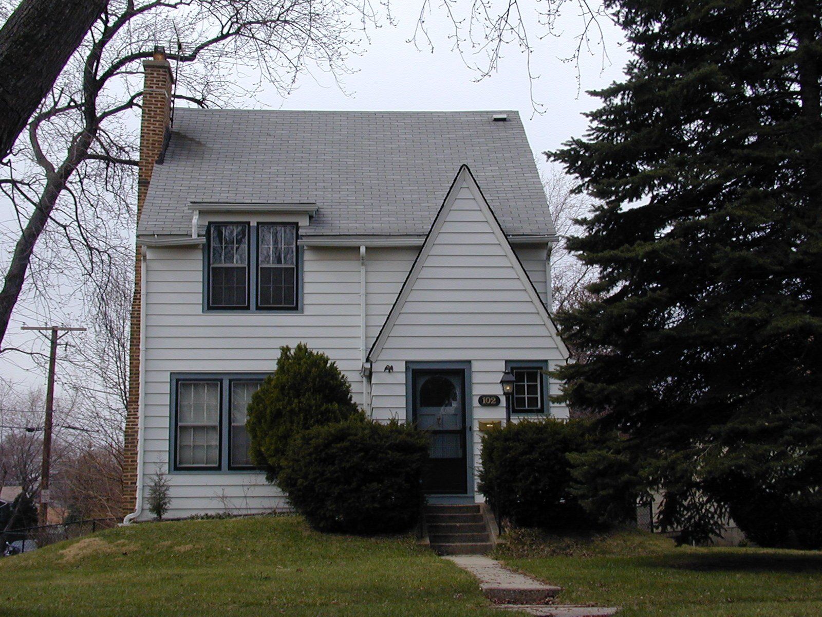 A white house with a chimney on the roof
