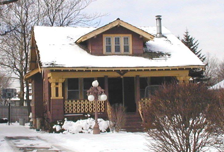 A house with snow on the roof and a porch