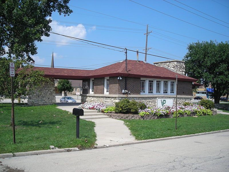 A house with a red roof and a mailbox in front of it