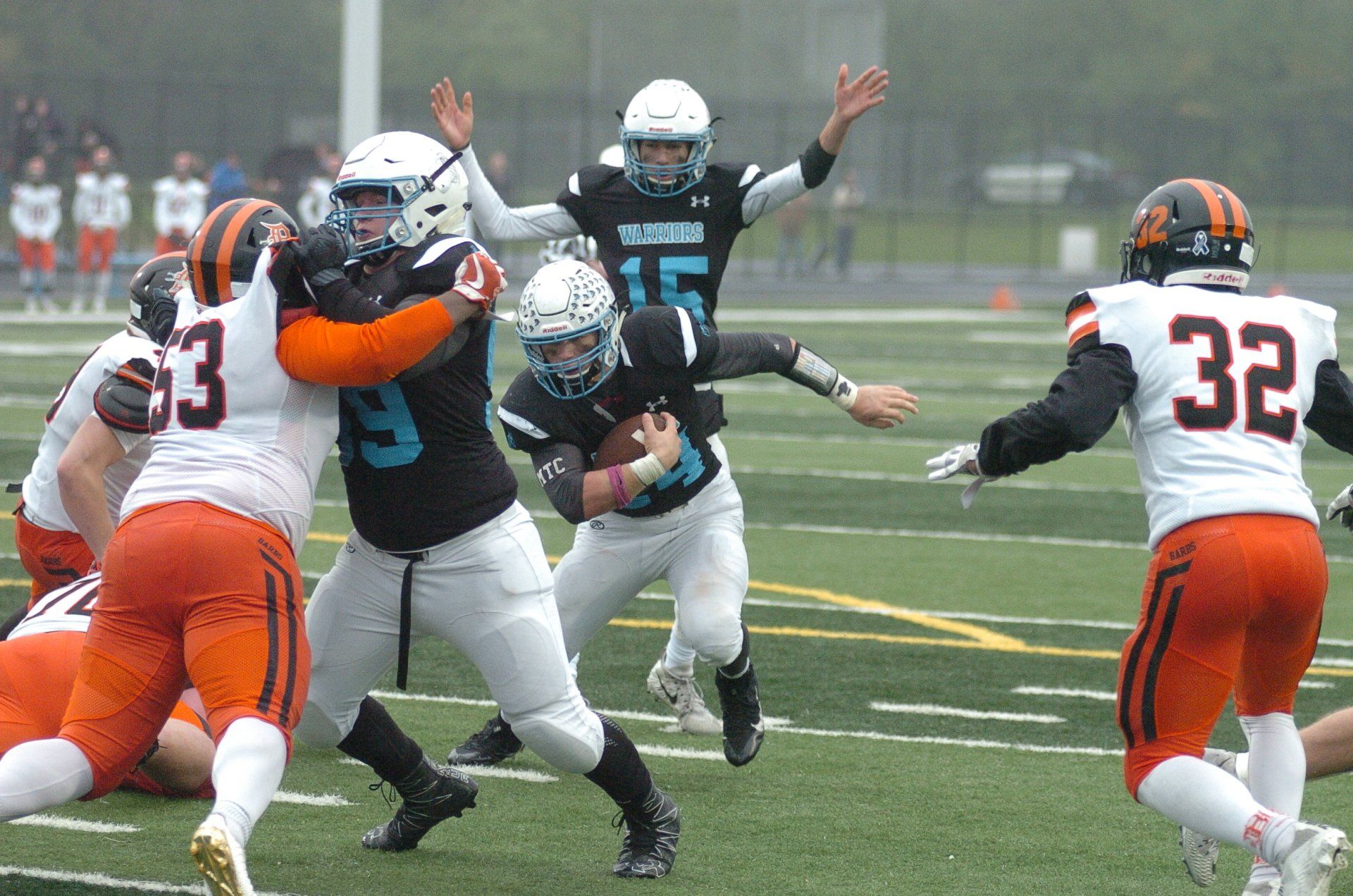 A group of football players are playing a game on a field.