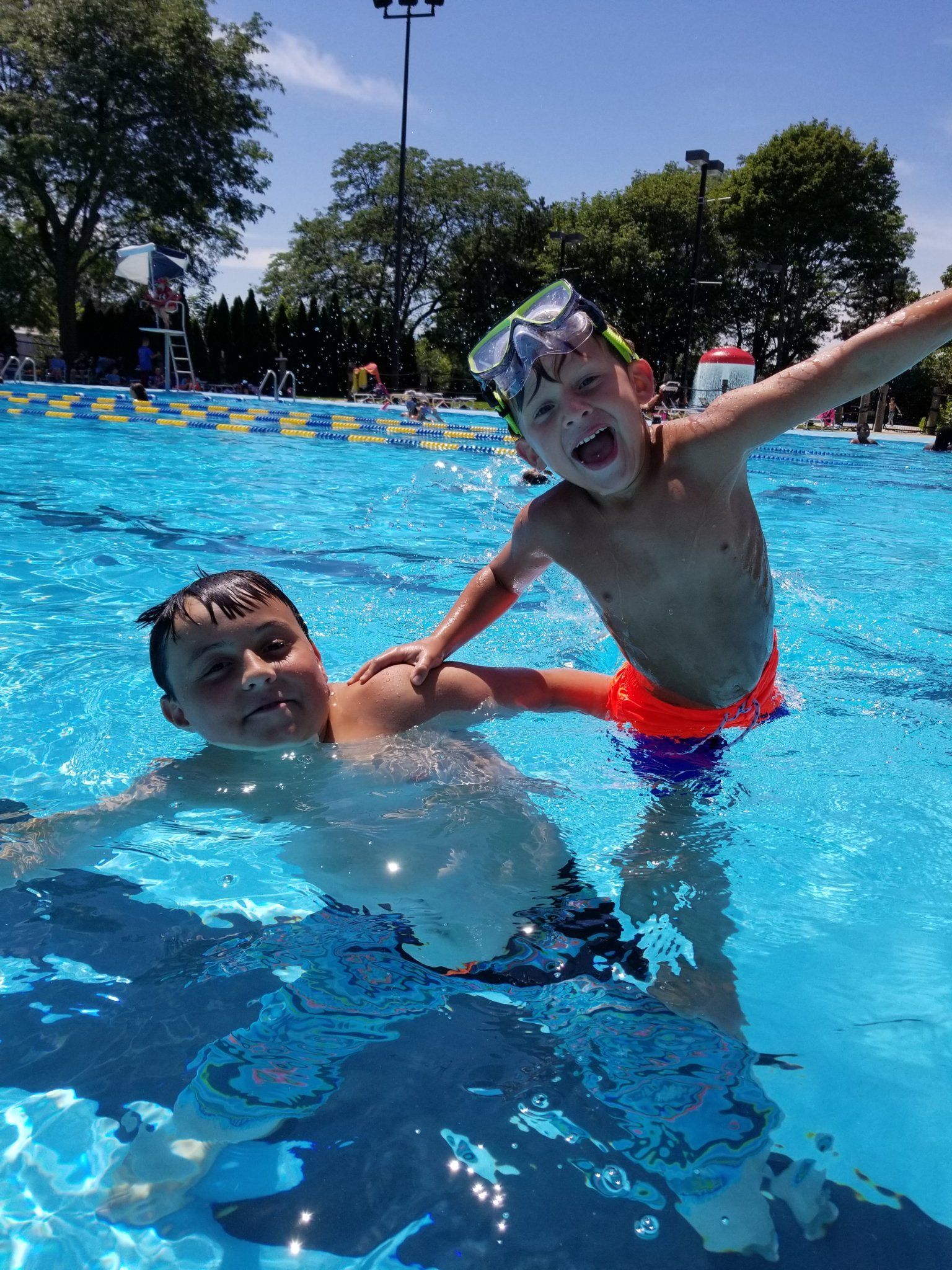 Two young boys are playing in a swimming pool