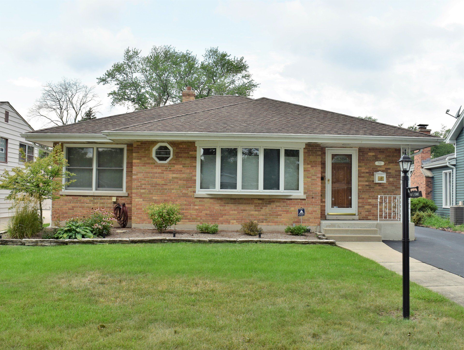 A brick house with a large lawn in front of it