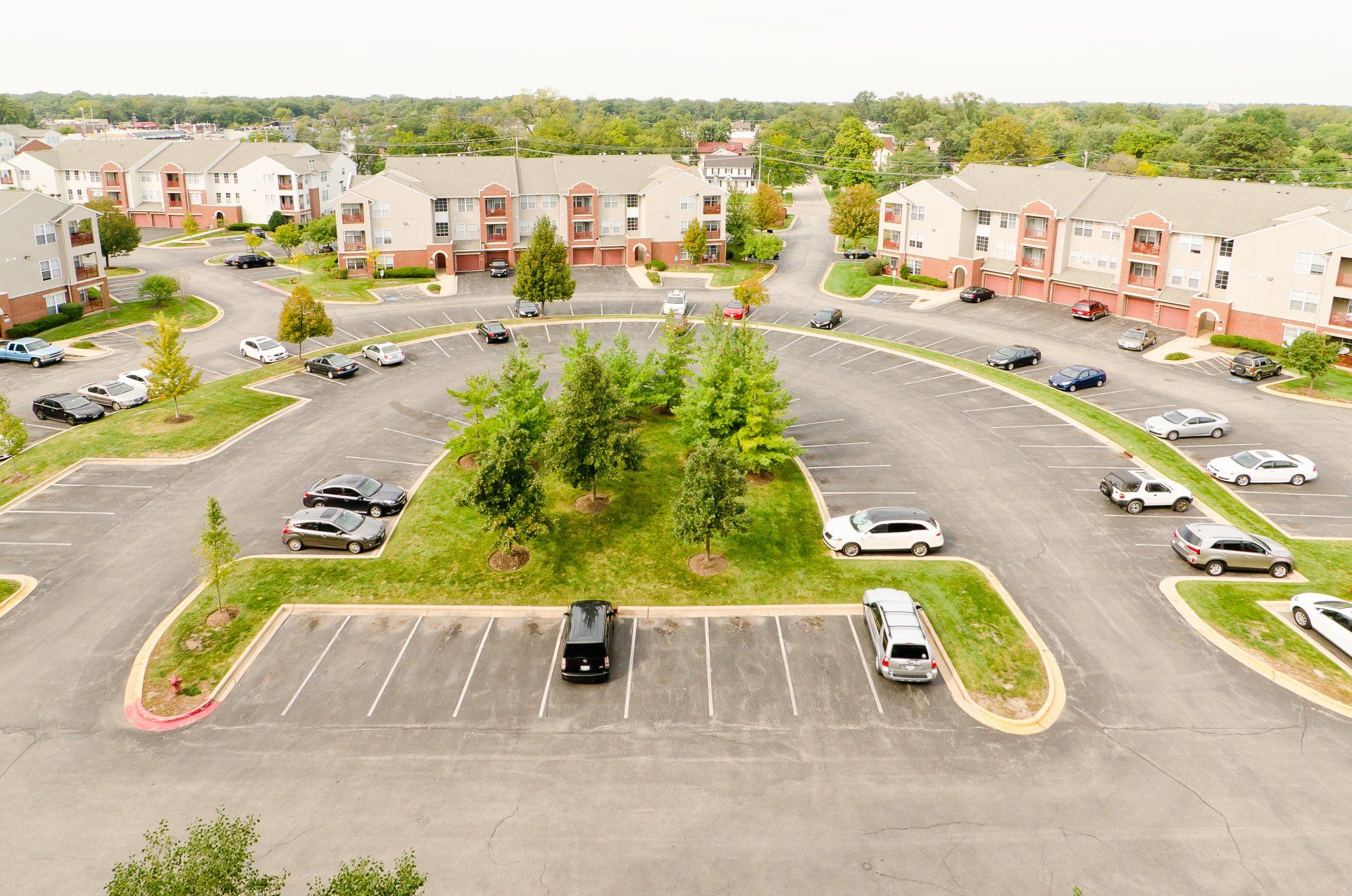 An aerial view of a parking lot in front of a apartment complex.