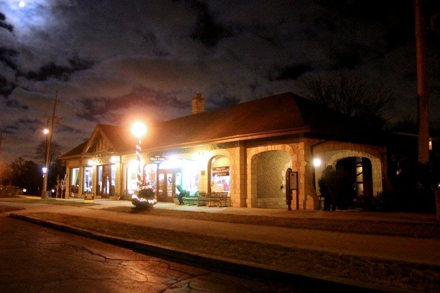 A building is lit up at night with a full moon in the background.