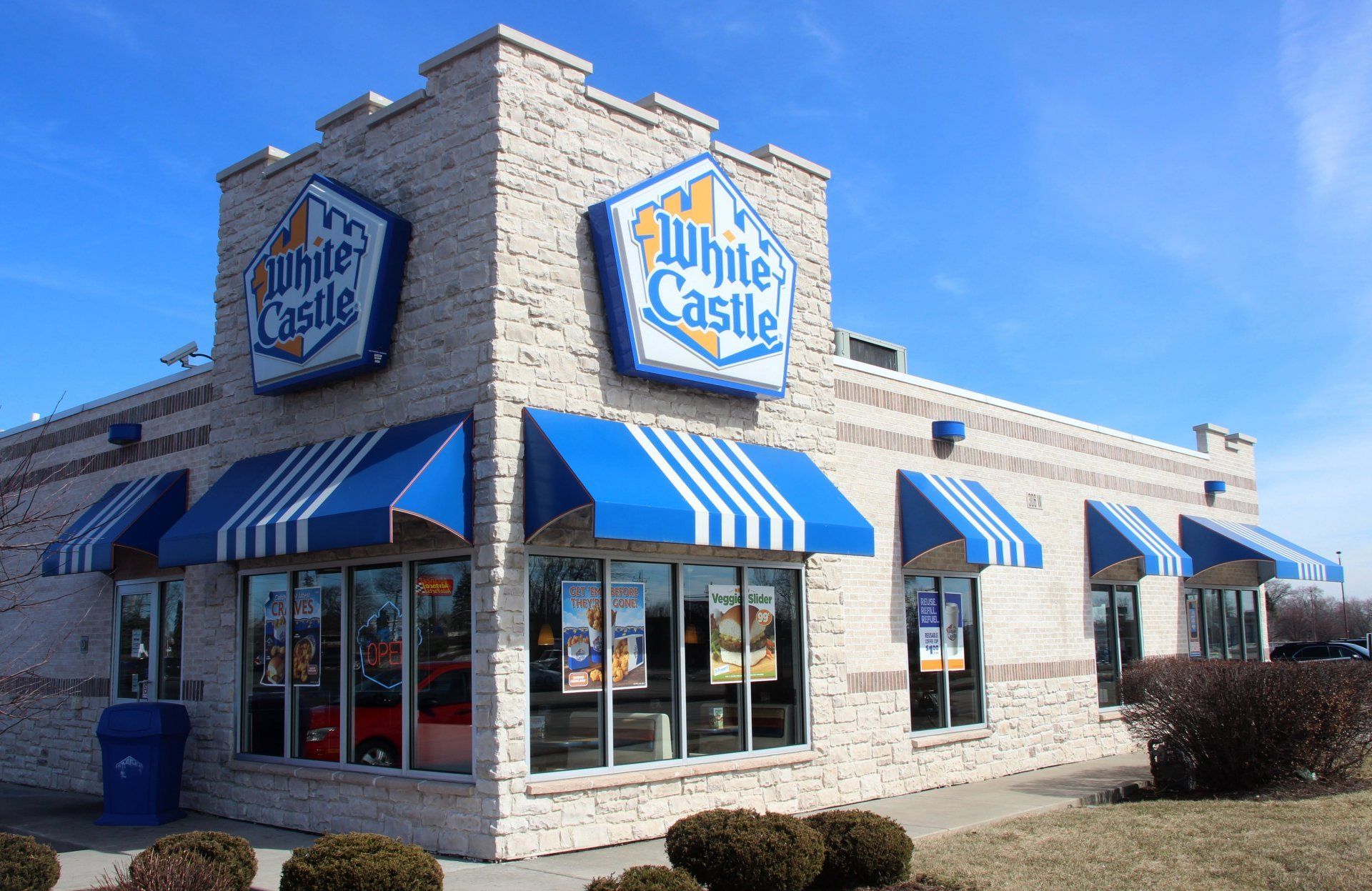 A white castle restaurant with blue and white awnings