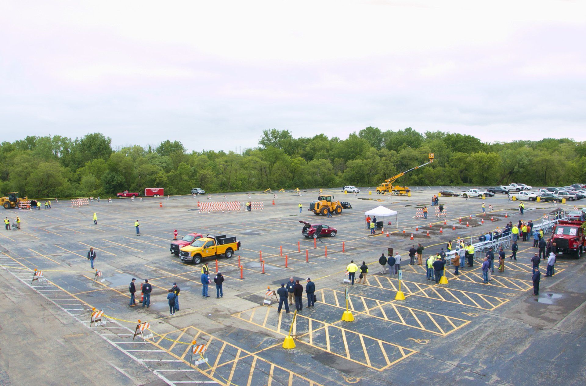A large parking lot with a lot of people and trucks