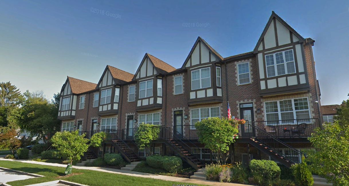 A row of houses are lined up next to each other on a sunny day.