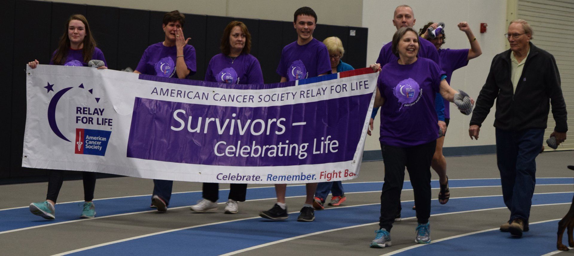 A group of people holding a banner that says survivors celebrating life