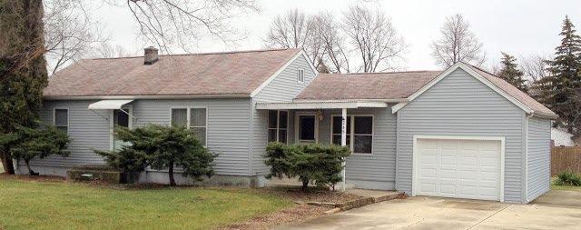 A small house with a garage in front of it.