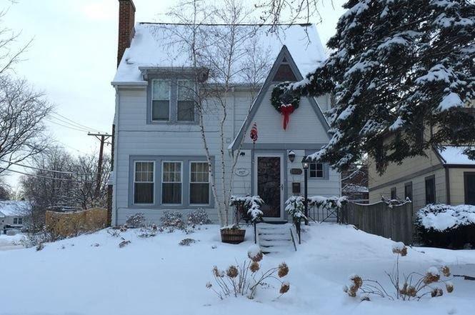 A snowy house with a wreath on the front door