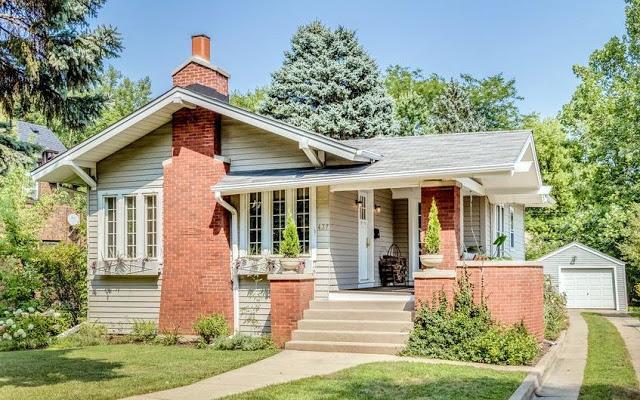 A small brick house with a porch and a garage.