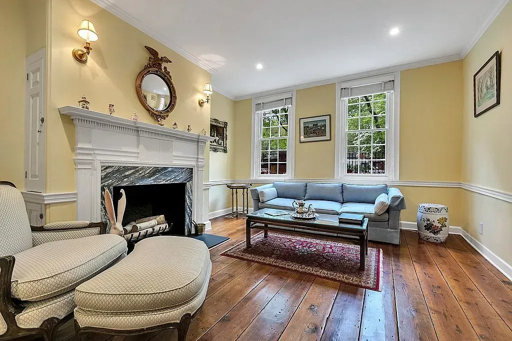 A living room with a couch , chair , coffee table and fireplace.