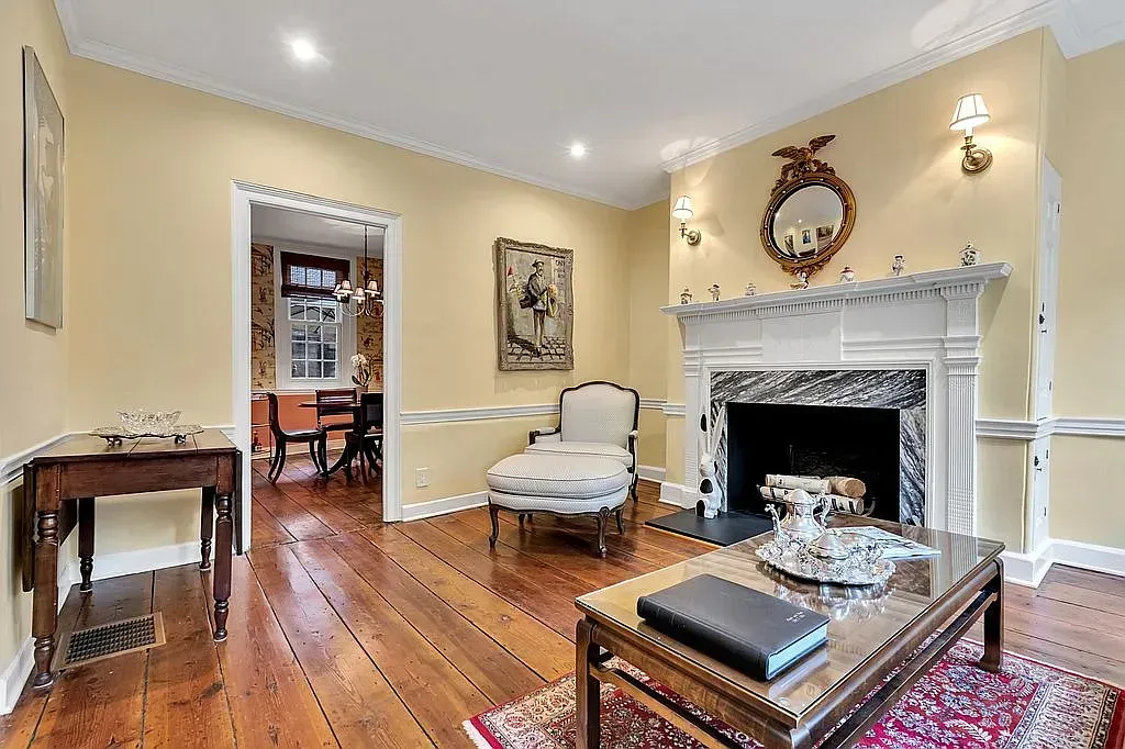 A living room with a fireplace , coffee table , chair and table.