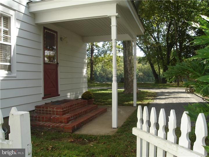 A white house with a porch and a white picket fence