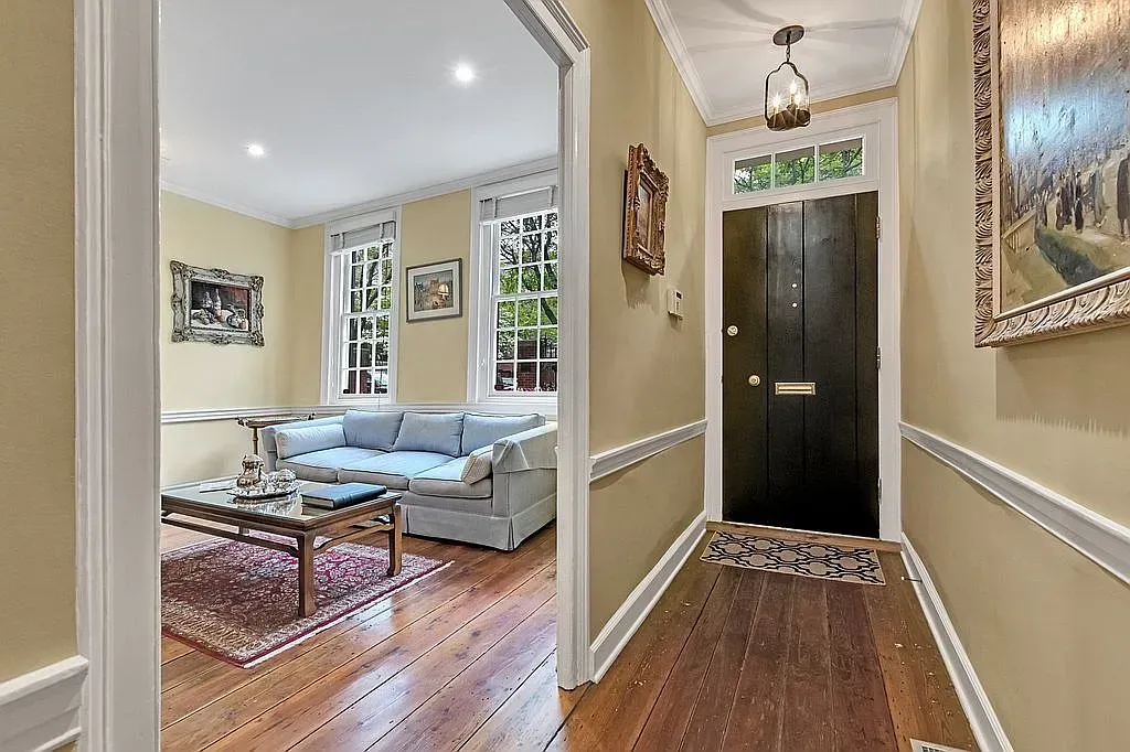 A hallway leading to a living room with a couch and a coffee table.