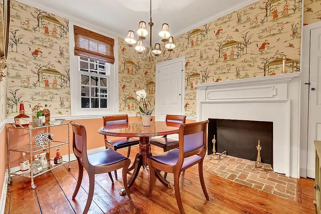 A dining room with a table and chairs and a fireplace.