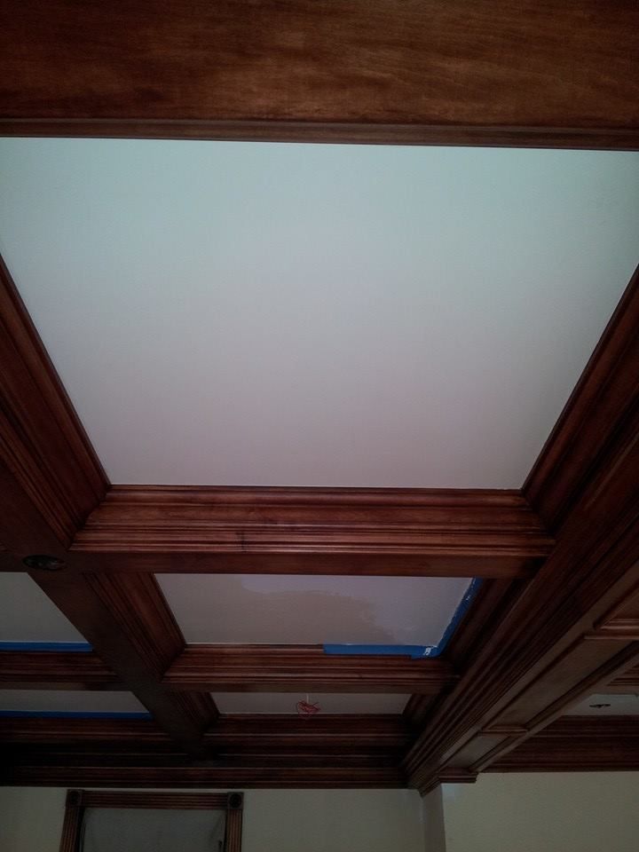 A ceiling with wooden beams and a white ceiling