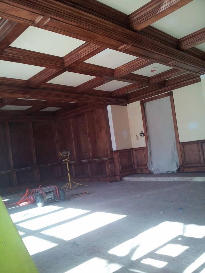 An empty room with wood paneling and a ceiling